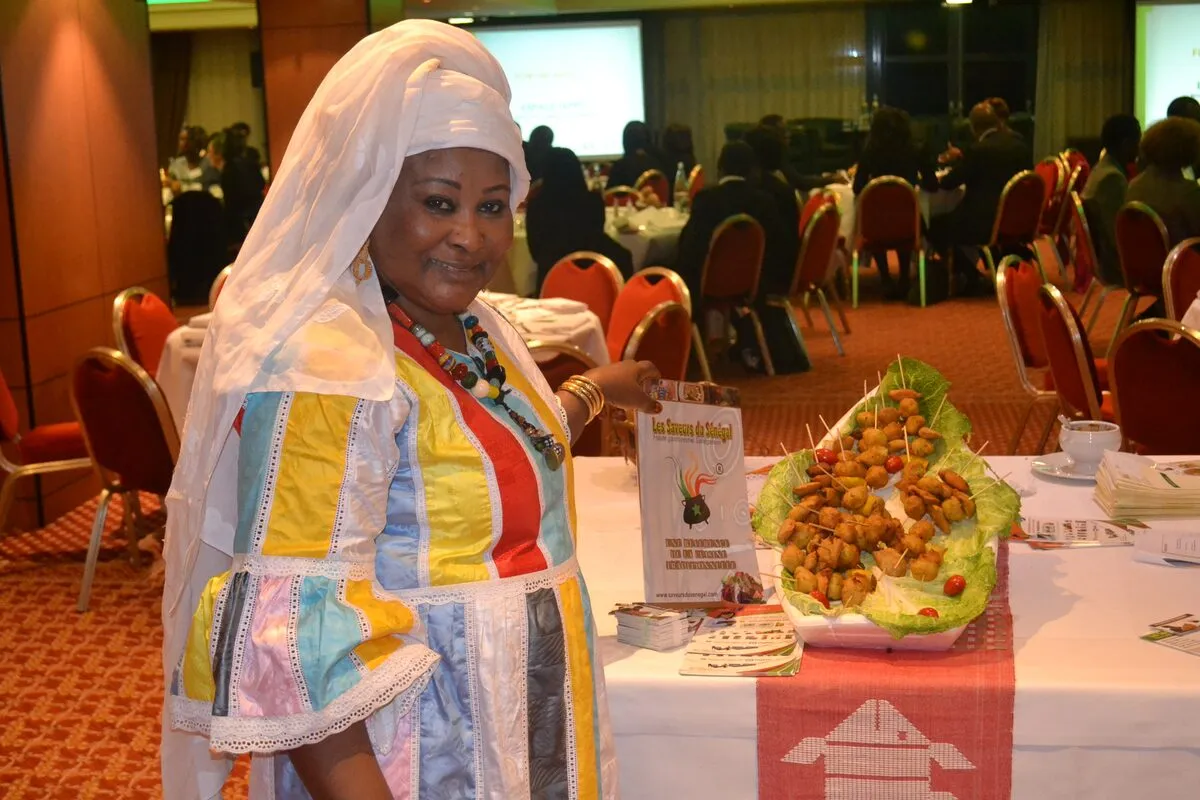 Une participante en tenue traditionnelle près du buffet